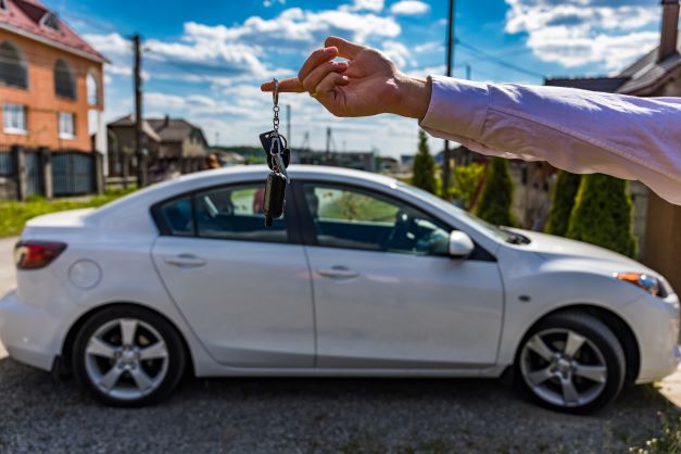 Someone holding keys in front of older car - Auto Insurance