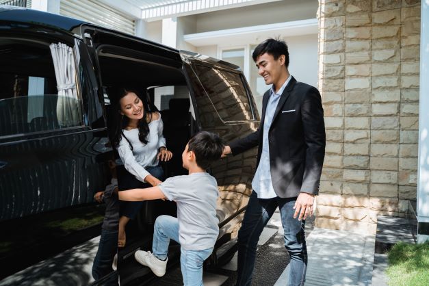 Family getting into car in front of their home - home & auto insurance bundle